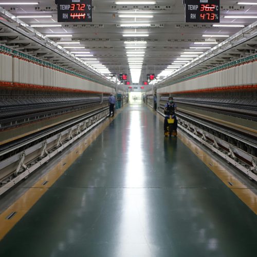 Spacious textile machinery hallway in an Indian industrial plant showing advanced equipment.
